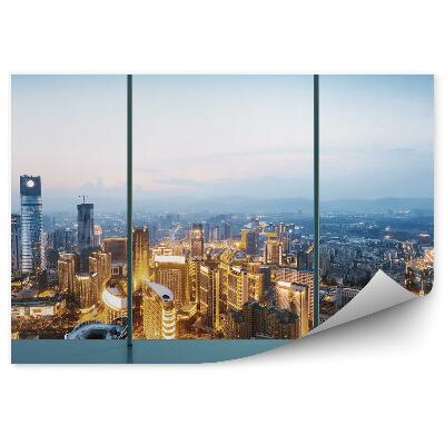 Fototapeta na ścianę Zmierzch oświetlone miasto widok z góry przez okno