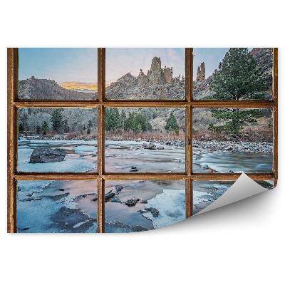 Fototapeta na ścianę Stare okno z widokiem na góry i zamarznięty potok